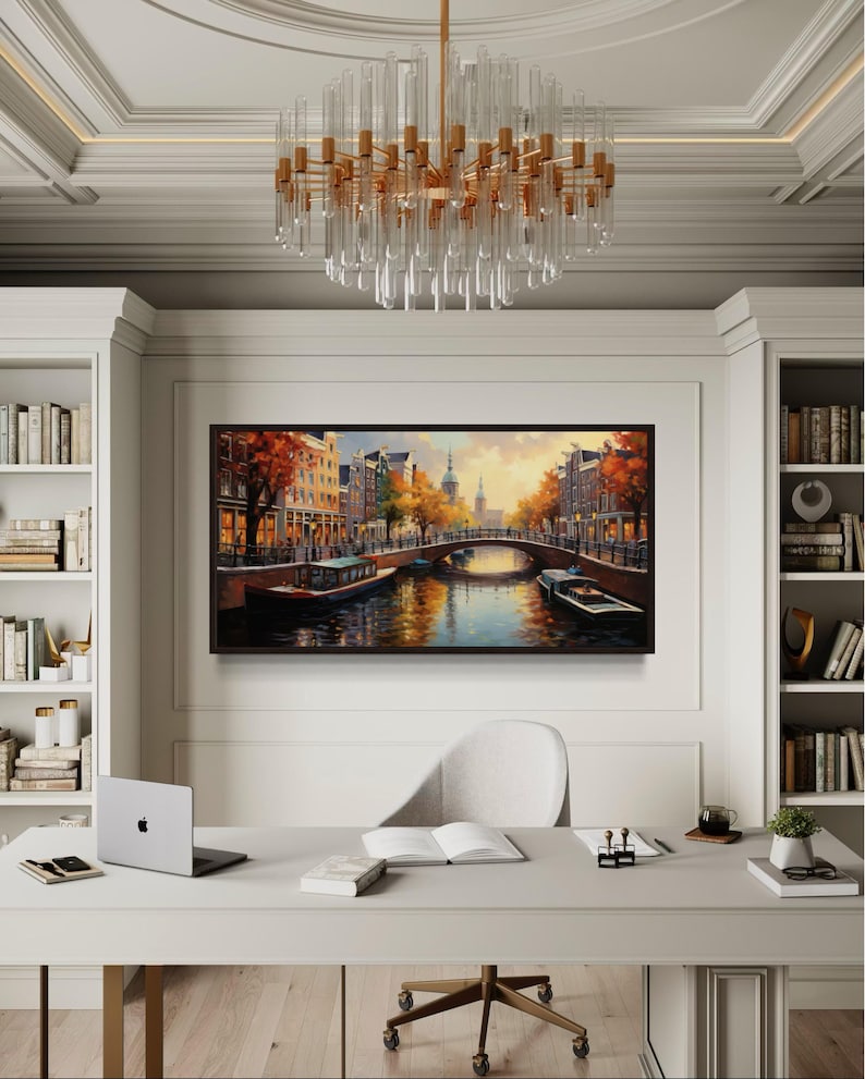 a modern office space with a large painting of a cityscape hanging on the wall, a chandelier, a desk with a laptop, and a bookshelf filled with books.