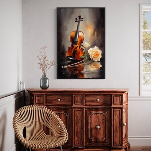 a framed painting of a violin and a rose on a wooden cabinet, with a woven chair in the foreground.