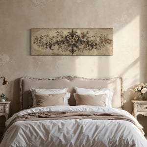 Peut inclure: Une œuvre d'art murale rectangulaire avec un motif floral gris, marron et crème est suspendue au-dessus d'un lit. Le lit a une tête de lit crème, une literie blanche et des coussins et une couverture bruns. La pièce a une palette de couleurs neutres.