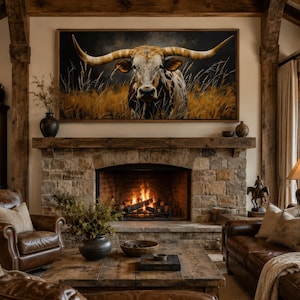 May include: A cozy living room with a stone fireplace and a large framed painting of a longhorn. The room features leather furniture, a wooden coffee table, and a warm, inviting atmosphere. The fireplace has a burning fire.