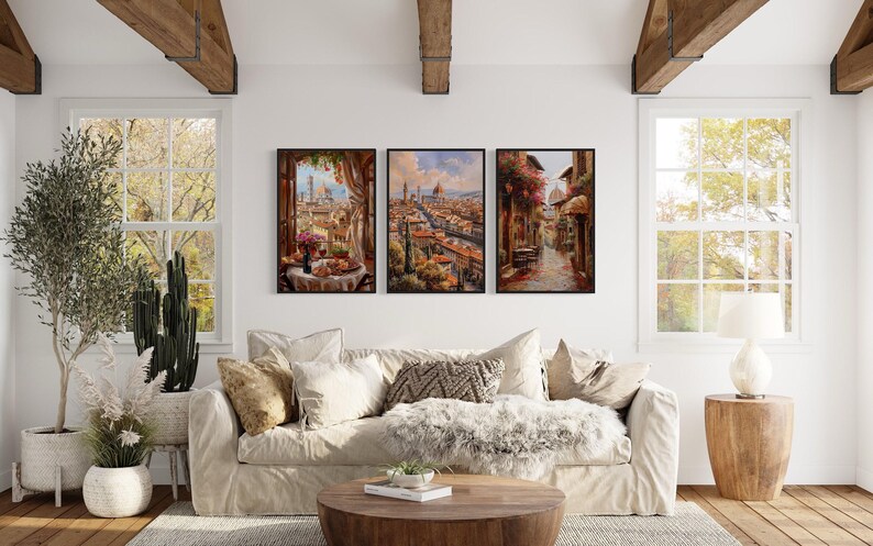 a cozy living room with a large window overlooking a picturesque cityscape. The room is decorated with a plush white sofa, a wooden coffee table, and various potted plants. Three framed pictures are hung on the wall, depicting a city scene with a bridge and a canal.