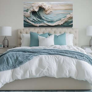 a serene and inviting bedroom with a large bed adorned with a white comforter and a blue throw blanket. The bed is flanked by two nightstands, each with a lamp, creating a cozy and well-lit atmosphere. Above the bed, a large painting of a crashing wave adds a touch of nature and artistic flair to the room.