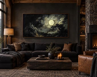 May include: A large rectangular framed wall art piece depicting a bright full moon illuminating a dark, cloudy night sky over a landscape of trees and hills, mounted on a dark wall above a dark gray sectional sofa with brown accent pillows.