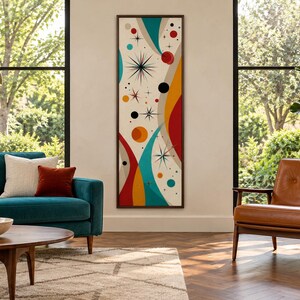 May include: A tall, rectangular wall art piece in a dark wood frame featuring a cream background with abstract shapes in red, orange, and teal, accented by black starbursts and circular dots arranged in a vertical, mid-century inspired composition.