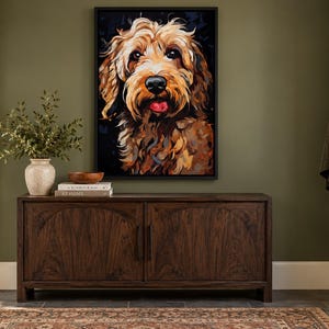 K&ouml;nnte beinhalten: Ein gerahmter Wandkunstdruck mit einem farbenfrohen, ausdrucksstarken Portr&auml;t eines goldbraunen Hundes mit schwarzer Nase und sichtbarer Zunge, platziert &uuml;ber einem dunklen Holzsideboard mit zwei T&uuml;ren und einer hellen Keramikvase.