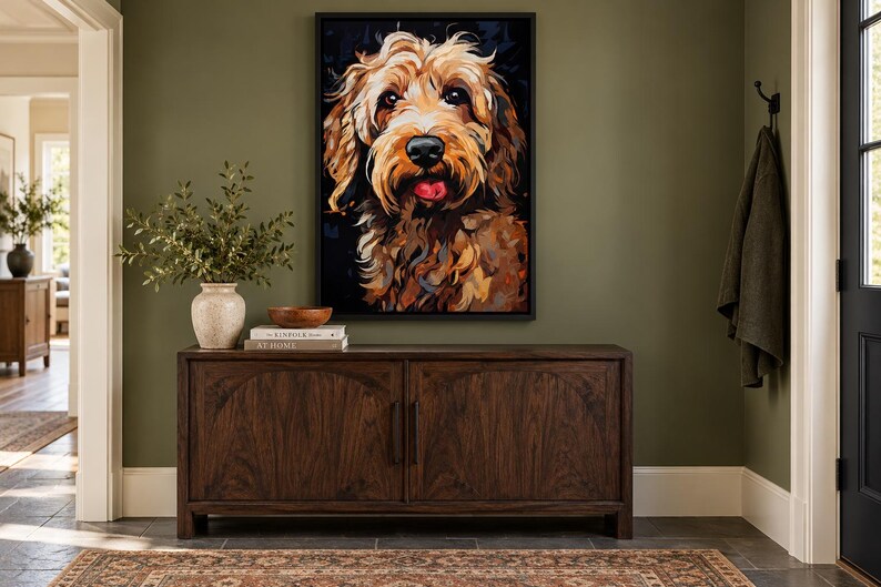 K&ouml;nnte beinhalten: Ein gerahmter Wandkunstdruck mit einem farbenfrohen, ausdrucksstarken Portr&auml;t eines goldbraunen Hundes mit schwarzer Nase und sichtbarer Zunge, platziert &uuml;ber einem dunklen Holzsideboard mit zwei T&uuml;ren und einer hellen Keramikvase.