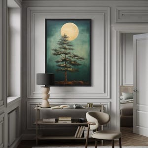 a serene indoor setting with a large framed painting of a tree with a full moon in the background, hanging on a wall above a small table with a lamp.