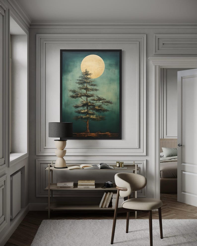 a serene indoor setting with a large framed painting of a tree with a full moon in the background, hanging on a wall above a small table with a lamp.