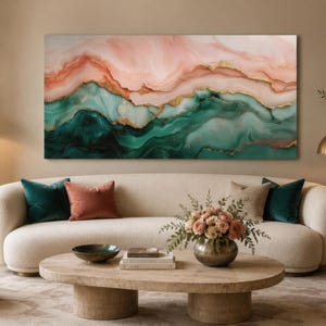 May include: Abstract art print featuring a flowing design in shades of pink, green, and gold. The artwork hangs above a cream-colored sofa with colorful throw pillows. The room is decorated with a modern aesthetic.