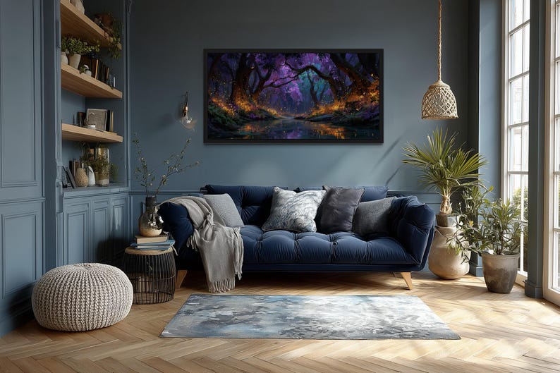 Op de afbeelding: Een ingelijst landschapsschilderij dat een mystieke bossc&egrave;ne met een reflecterend water weergeeft. Het kunstwerk heeft een donker kleurenpalet met paarse, blauwe en oranje tinten. Het schilderij hangt boven een blauwe bank met decoratieve kussens.