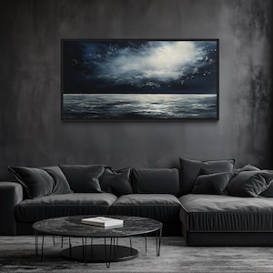 a modern living room with a large black sectional sofa, a round black coffee table, and a large black painting hanging on the wall above the sofa.