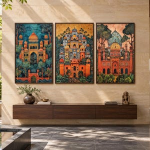May include: A set of three framed rectangular wall art prints featuring intricate architectural structures with domes and arches, rendered in vibrant shades of orange, teal, and gold, displayed above a long, dark brown wooden console table.