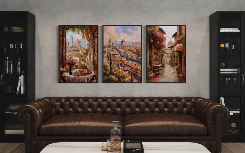 a cozy living room with a brown leather sofa and a coffee table in front of it. Above the sofa, there are three framed paintings depicting different scenes, including a cityscape, a street scene, and a garden. The paintings are hung on the wall, creating a visually appealing and harmonious space.
