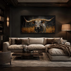 May include: A luxurious living room with a large beige sectional sofa, a dark wood coffee table, and a framed painting of a longhorn. The room features a bookshelf, a floor lamp, and a fireplace, creating a cozy and elegant atmosphere.