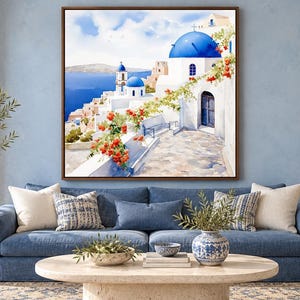May include: A square wall art print featuring a Mediterranean coastal scene with white buildings, bright blue domes, and a stone pathway. Vibrant orange flowers drape over a white wall in the foreground, overlooking a deep blue sea under a clear sky.