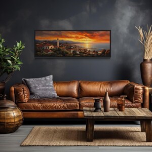 a cozy living room with a large brown leather sofa, a wooden coffee table, and a framed landscape painting hanging on the wall.