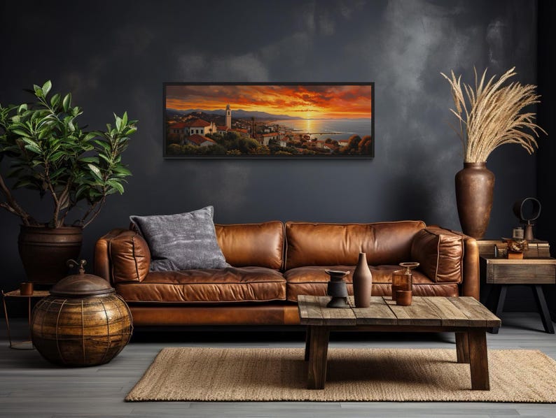 a cozy living room with a large brown leather sofa, a wooden coffee table, and a framed landscape painting hanging on the wall.