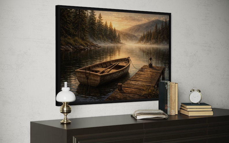 May include: A framed landscape art print depicts a serene lake scene with a wooden boat tied to a dock. The artwork features a misty atmosphere, with trees and mountains in the background. The color palette includes browns, greens, and soft yellows.