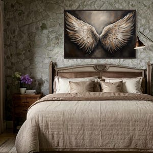 a bedroom with a large bed, a painting of large wings on the wall, and a window with curtains.