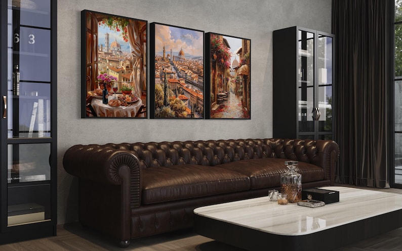 a modern living room with a large brown leather sofa, a white coffee table, and three framed paintings hanging on the wall above the sofa.
