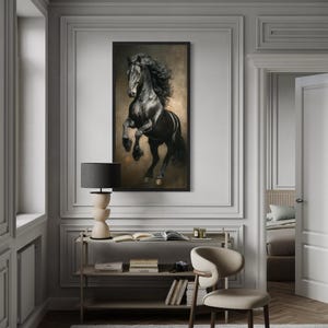 a large black horse painting hanging on a white wall in a room with a wooden floor and a beige chair.