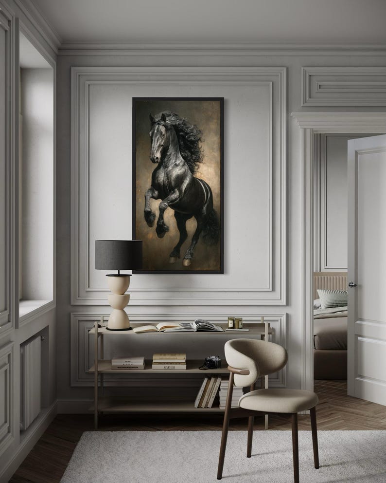 a large black horse painting hanging on a white wall in a room with a wooden floor and a beige chair.