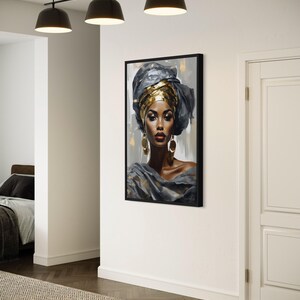 a large framed portrait of a woman with a headdress, hanging on a white wall in a room with a wooden floor.