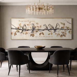 May include: A rectangular wall art piece featuring five birds perched on a branch with autumn-toned leaves. The text "His eye is on the sparrow" and "and I know He watches me" is printed in a cursive script across the cream-colored background.