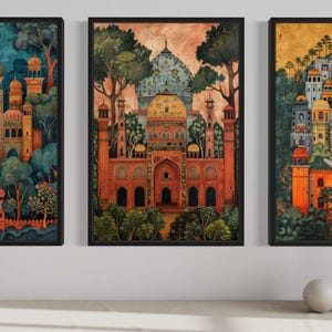 three framed paintings of ornate, colorful buildings set against a lush, green landscape. The paintings are arranged in a row on a wall, with a vase and two white bowls placed in front of them.