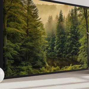 a large framed picture of a forest scene with a lake in the background, placed on a wall. There are two white vases and a potted plant to the right of the picture.