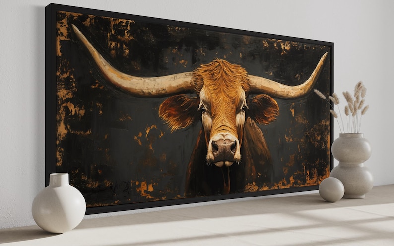 a large painting of a bull with long horns, displayed on a wall. The bull is the central focus of the painting, with its distinctive horns prominently featured. The painting is framed and placed on a white wall, with two white vases positioned on either side of it.