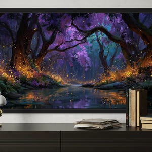Op de afbeelding: Een ingelijste kunstdruk die een mystieke bossc&egrave;ne met een rivier afbeeldt. Het kunstwerk heeft een levendig kleurenpalet van paars, blauw en goud, met gedetailleerde bomen en gloeiende deeltjes. De print wordt getoond op een zwarte kast.