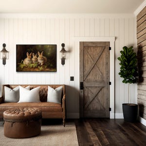 a cozy living room with a brown leather sofa, a wooden door, and a painting of three rabbits on the wall. The room has a rustic, country-style decor with wooden walls and a wooden floor.