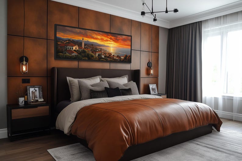 a modern bedroom with a large bed, dark wood paneling, and a large window. The bed is covered in a brown leather comforter and has a framed landscape painting above it. The room has a warm, inviting atmosphere with the wooden paneling and the natural light coming through the window.
