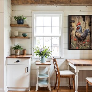 a cozy and rustic kitchen with a wooden table and chairs, a white cabinet, and a framed painting of a rooster on the wall.