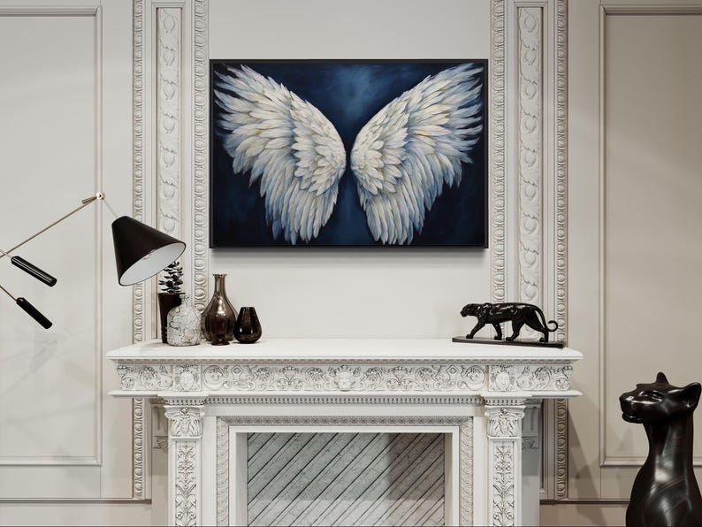 a white fireplace with a large painting of white wings hanging above it. The fireplace is decorated with various items, including a black cat statue, a vase, and a lamp.