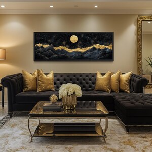 May include: An opulent living room with a black buttoned sofa and gold cushions. A landscape painting with a moon and gold mountains is above the sofa. A gold-framed mirror and coffee table add to the elegant decor.