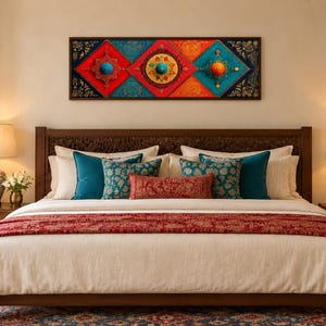 Puede incluir: Un dormitorio con una estructura de cama de madera, un edred&oacute;n color crema y un camino de mesa rojo con patrones. La cama est&aacute; decorada con cojines de color azul cerceta y estampados. Sobre el cabecero cuelga un arte mural con paneles geom&eacute;tricos.