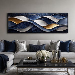 May include: A rectangular wall art piece featuring a horizontal abstract composition of flowing, layered waves in deep navy blue, metallic gold, and silver tones, all enclosed within a thin black frame, creating a sense of movement and depth.