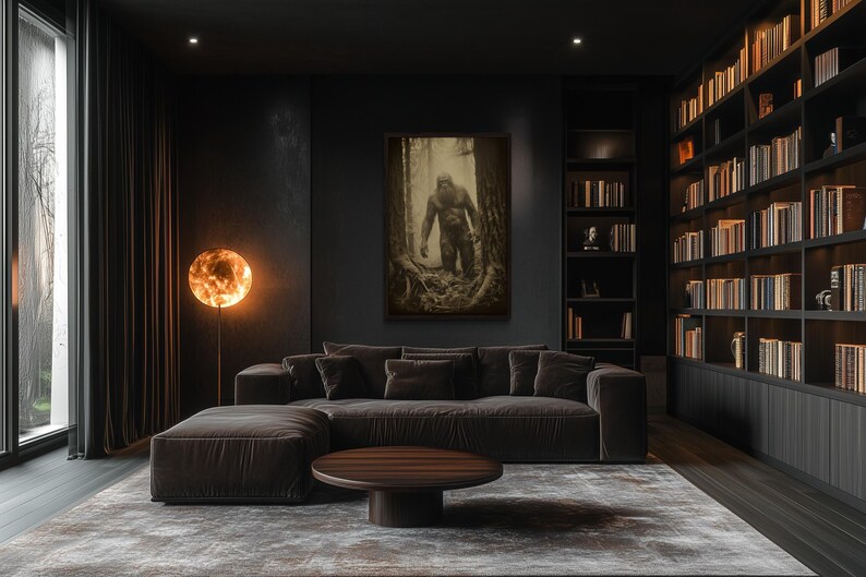 a modern living room with a large bookshelf filled with books, a comfortable sofa, and a round coffee table. The room has a dark color scheme and a large window that allows natural light to enter the space.
