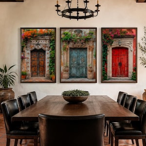 May include: A set of three framed wall art prints depicting ornate architectural doorways. The left print shows a brown wooden door with orange flowers, the centre a teal door with green foliage, and the right a vibrant red door with pink flowers.