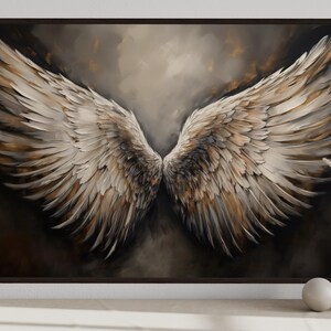 a large painting of a pair of angelic wings, with a dark background and a warm color palette. The painting is framed and displayed on a wall, with a vase of dried flowers and a small white sculpture placed next to it.