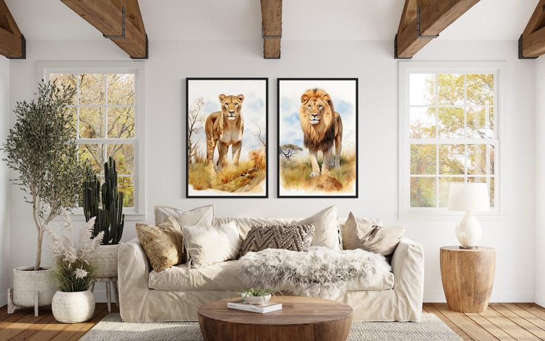 a living room with a large window, a white sofa, and two framed paintings of lions on the wall.