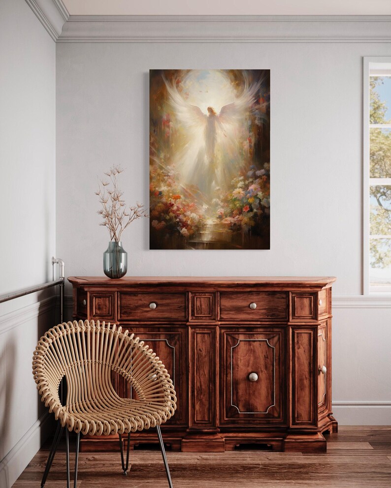 a large painting of an angel with wings, hanging on a wall above a wooden cabinet or dresser. The painting is surrounded by a floral arrangement, and there is a woven chair in the foreground.