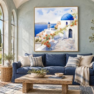 May include: A square wall art print featuring a Mediterranean coastal scene with white buildings, bright blue domes, and vibrant orange flowers overlooking a deep blue sea, framed in a thin gold border and displayed on a wall.