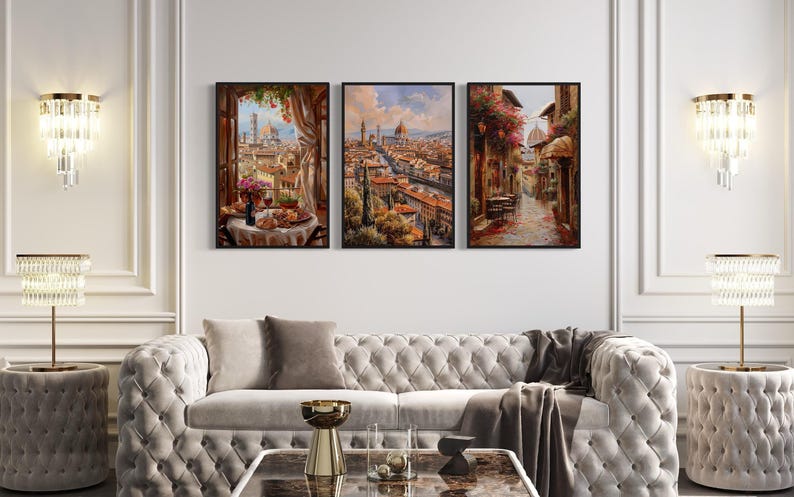 A luxurious living room with a white tufted sofa, a coffee table, and three framed paintings depicting scenes of a city and a garden.