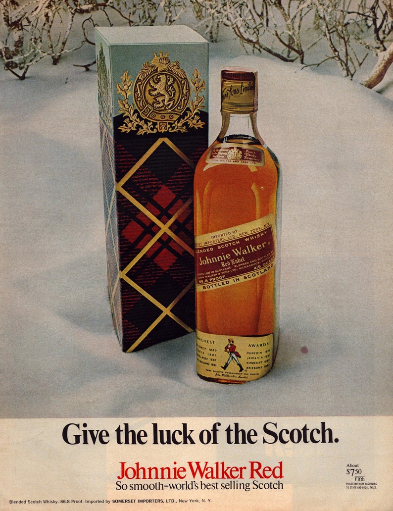 May include: A bottle of Johnnie Walker Red Label Scotch whisky with a red and gold label. The bottle is sitting on a snowy surface with a box behind it. The box is red and gold with a plaid pattern. The text on the bottle reads "Imported by Somerset Importers, Ltd., New York, N.Y.". The text on the box reads "Johnnie Walker Red Label Blended Scotch Whisky 86.8 Proof."
