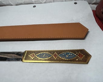 Vintage metal letter opener with a brass finish and ornate enameled top in rich