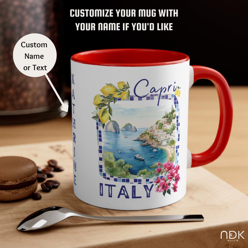 May include: White ceramic mug with a red rim and handle. The mug features a watercolor illustration of Capri, Italy, with a blue and white tiled border and the words "Capri" and "ITALY".