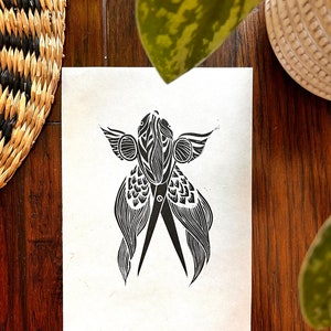May include: Black and white linocut print of a pair of scissors with wings. The scissors are stylized and have a detailed design.